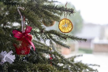 Christmas tree with decorations. Selective focus on the orange mandarin clipart
