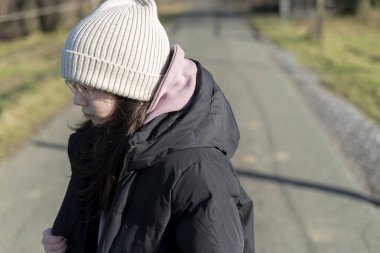 Küçük bir kızın, asfalt yolda yürüdüğünü gördüm.