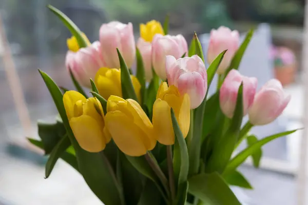 stock image A bouquet of multi-colored tulips on the table. The concept of spring joy, celebration and freshness