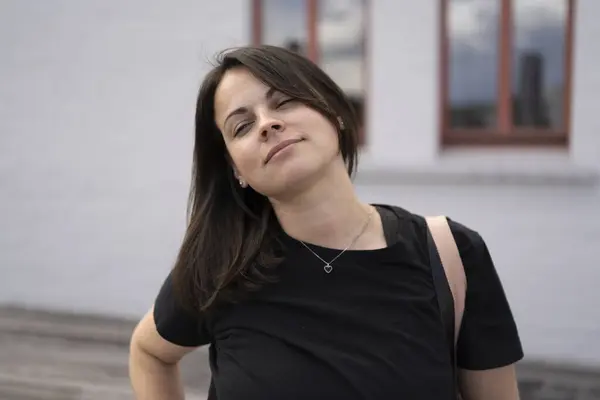 stock image Beautiful girl in a black T-shirt against the backdrop of a city landscape.