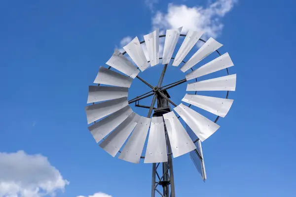 stock image Photo of a mini wind turbine against a background of blue sky with clouds. Green energy concept at home