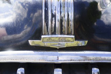 Iserlohn Gruermannscheide, NRW, Almanya. 13 Temmuz 2024. Eski bir otomobil fuarında eski bir Amerikan Pontiac Chieftain arabasının kaputunda amblem var.