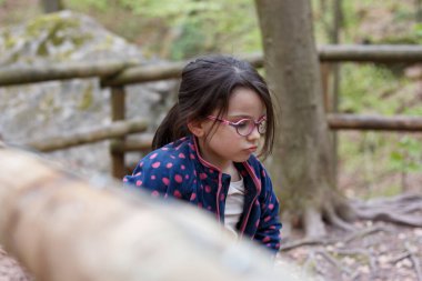 Dağlarda gözlüklü küçük kız. Yürüyüşe çıkmış küçük bir gezgin. Çocuk gezintisi kavramı