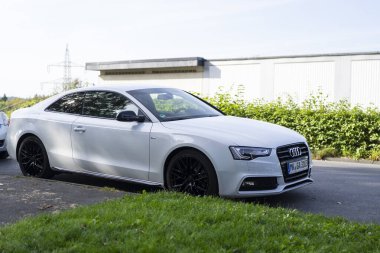 Iserlohn, NRW, Almanya. 22 Eylül 2024. Otoparka park etmiş beyaz bir Audi A5 spor arabası.
