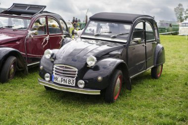 Iserlohn Gruermannscheide, NRW, Almanya. 13 Temmuz 2024. Yaşlı siyah Citroen 2cv yeşil çimlerde