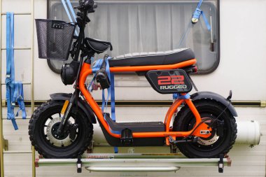 Iserlohn Gruermannscheide, NRW, Almanya. 13 Temmuz 2024. Elektomotosiklet Rugged 22 Tekerlekli evin arka duvarına yapışık