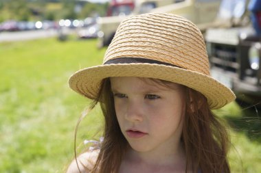 Yazın açık havada küçük, düşünceli bir kız ve hasır şapkalı bir kız. Çocuk sağlığı, eğitim, aktif eğlence kavramı