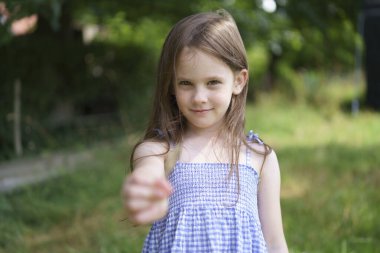 Çimlere yakın çekimde güzel bir kız. Çocuk sağlığı, seyahat, eğlence kavramı