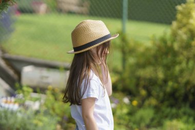 Yazın arka bahçede tek dişi olmayan hasır şapkalı şirin bir kız. Neşeli, sağlıklı bir çocuk kavramı