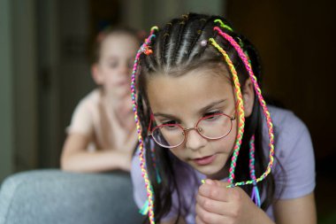 Two cute sisters with dreadlocks in the room. Concept of active family clipart