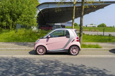 Iserlohn, NRW, Almanya. 10 Mayıs 2024. Bahar caddesinde iki kişi için güzel pembe akıllı. Yan görünüm