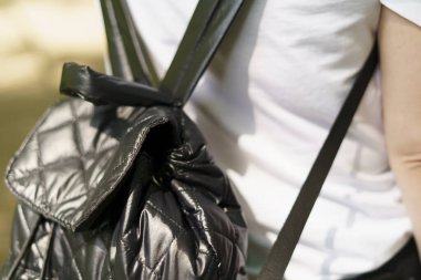 Bir kadının sırtında siyah bir sırt çantası. Feminist seyahat konsepti