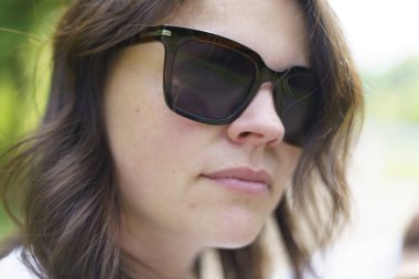 Beyaz tişörtlü, gülümseyen siyah saçlı ve yaz tatilinde omuzlarında sırt çantasıyla güzel bir kız. Yaya gezisi konsepti