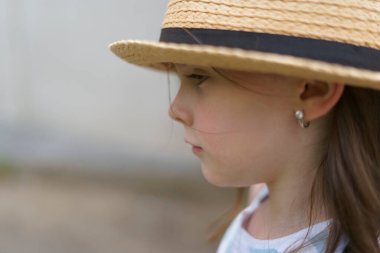 Sırt çantalı saman şallı küçük tatlı kız yazın seyahat ediyor. Bir çocuğun neşeli, aktif, sağlıklı çocuğu kavramı