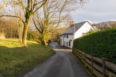 Narrow German country road among fields and dark spring sky. Beautiful landscape among European hills clipart