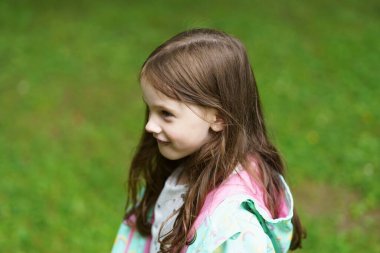 Oyun parkında yağmurlukla yalnız üzgün bir kız. Zor çocukluk ve psikolojik sorunlar kavramı