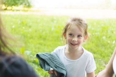 Yazın parkta beyaz tişörtlü tatlı sarışın kız. Çocuk aktivitesi ve eğlence konsepti