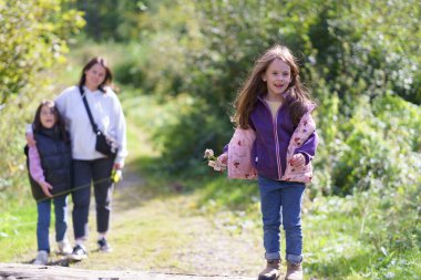 Çocuklar ve anneleri sık bir ormanda yürüyüşe çıktılar. Doğada bir aile gezisi kavramı