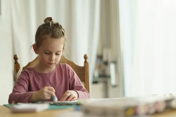 Küçük tatlı kız dikiş işine konsantre oluyor. Çocukların yaratıcılığının eğitici kavramı