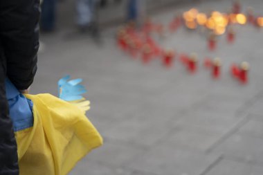 Ukrayna 'ya destek için düzenlenen mitingde mum ve fenerlerin arka planında Ukrayna bayrakları.