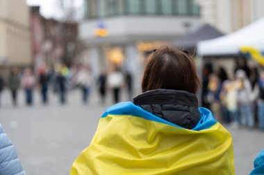 Ukrayna 'yı destekleyen bir mitingde omuzlarında Ukrayna bayraklarıyla tanınmayan insanlar arkadan fotoğraflandı.