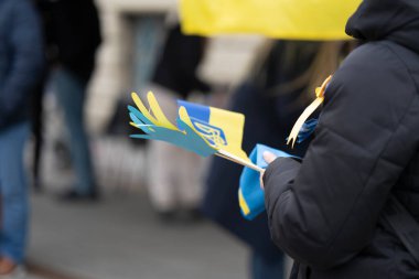 Yas mitinginde bulanık bir arka plana karşı Ukrayna sembolleri.