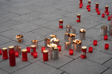 Lit candles and lanterns in the square as a sign of mourning. Concept of grief for the deceased. clipart