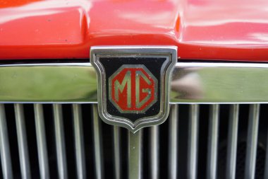 Iserlohn Gruermannscheide, NRW, Almanya. 13 Temmuz 2024. Yazın Vintage Car Show 'da kırmızı MG MGB GT amblemi.