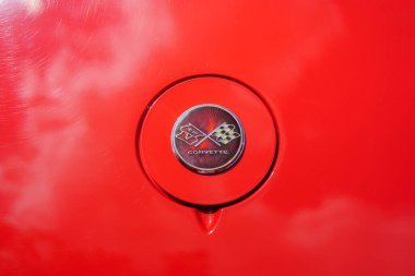 Iserlohn Gruermannscheide, NRW, Almanya. 13 Temmuz 2024. Yazın araba fuarında kırmızı bir Chevrolet Corvette C3 amblemi..