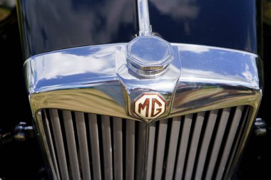 Iserlohn Gruermannscheide, NRW, Almanya. 13 Temmuz 2024. Yazın klasik bir araba sergisinde siyah bir MG 'nin amblemi..