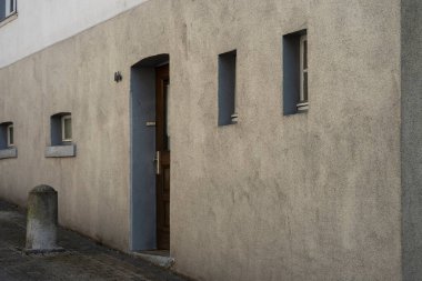 Altena, NRW, Almanya. 9 Mart 2025. Pencereli ve kapılı beyaz evin açılı fotoğrafı. Çizgi ve şekil kavramı