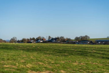Baharda mavi gökyüzü ve ufukta bulutlar olan kırsal bölgelerin panoramik fotoğrafı. Alman manzara konsepti