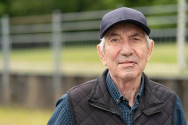 Şapka ve yelek giyen mutlu bir son sınıf öğrencisi bahar gününün tadını çıkarıyor. Kavram: yaşam deneyimi, doğa bağlantısı, pozitif ruh, sakin anlar.