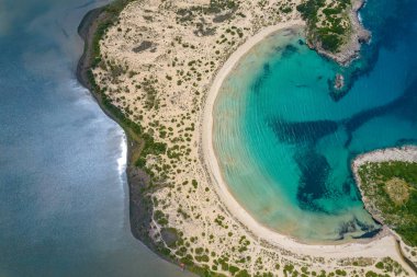 Messinia, Gialova, Moreloponnese, Yunanistan 'daki Voidokoilia' nın ikonik yarı dairesel kumlu plajının insansız hava aracı fotoğrafı