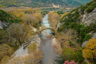 Top down aerial view  of the  old stone bridge in Klidonia  during fall season.  This arch bridge was built in 1853 and it is situated on the river of Voidomatis in  Zagori, Epirus Greece.