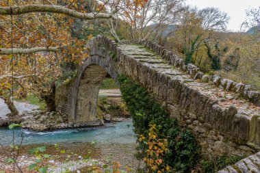 Old stone bridge in Klidonia  during fall season.  This arch bridge was built in 1853 and it is situated on the river of Voidomatis in  Zagori, Epirus Greece.