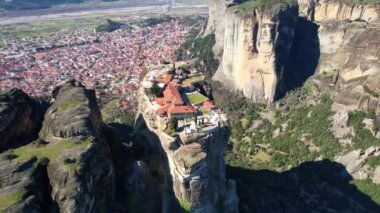 Aerial video of Agia triada , Holy Trinity monastery, an unesco world heritage site,  located on a unique rock formation  above the village of Kalambaka during fall season.