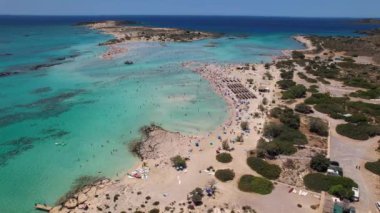 Yunanistan, Girit, Chania 'da turkuaz suları ve pembe kumu olan ünlü Elafonisi plajının klibi..
