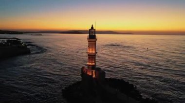 Günbatımında Yunanistan 'ın Girit kentindeki Chania kentinin ikonik eski deniz fenerinin klibi