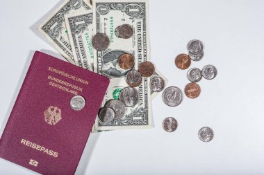 travelling with money: american dollars in bills and coins and a passport