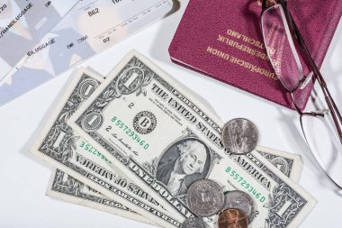 travelling with money: american dollars in bills and coins and a passport