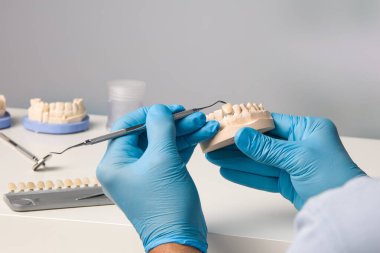 Diş laboratuarında diş kaplaması üzerinde çalışan diş teknisyenini kapatın.