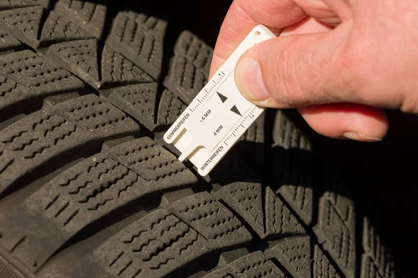 stock image close-up of measuring tread depth of car tire for safety reasons