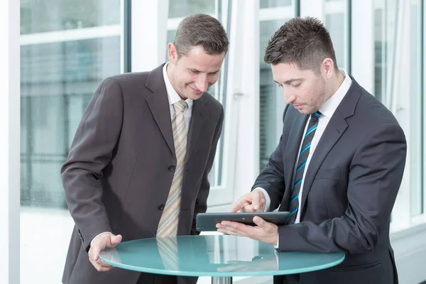 Zwei Junge Geschäftsleute Sprechen Und Arbeiten Mit Einem Computer Tablet — Stockfoto