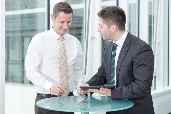 Zwei Junge Geschäftsleute Sprechen Und Arbeiten Mit Einem Computer Tablet — Stockfoto