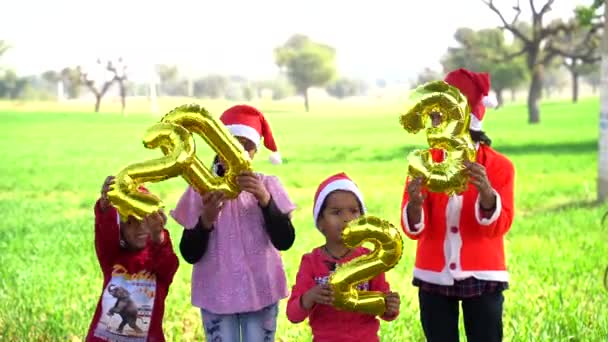 庭で大晦日を祝う子供たちは 次の新年を表すイルミネーション番号2023を保持します — ストック動画