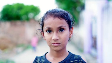 Kameraya gülümseyen mutlu Hintli kız çocuğu. Delhi, Hindistan - Kasım 2022.