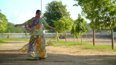 Güzel Hintli bir kızın portresi. Genç Hintli kadın model. Navaratri için geleneksel Hint kostümü lehenga choli. Yeşil arka planda güzel bir Hintli kız. ghoomer dansı