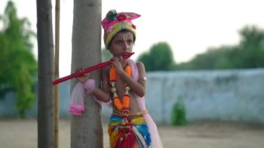 Küçük Tanrı Krishna kaçıyor. Lord Krishna Janmashtami diliyor. Krishna Kanha 'daki sevimli Hintli bebek ya da flütüyle poz veren kanhaiya elbisesi.