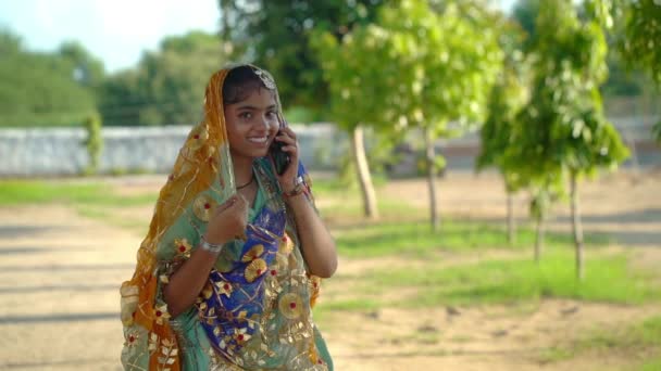 美しいインドの女の子の肖像画 ヒンドゥーの若い女性モデル 伝統的なインドのコスチュームナヴァラトリ 緑の背景の若い美しいインドの女の子 スマートフォン付きの女の子 — ストック動画